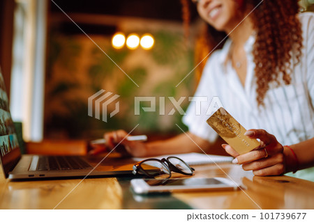 Young woman sitting at cafe making online shopping, using credit card and laptop. Online shopping Young woman sitting at cafe making online shopping, using credit card and laptop. Online shopping 101739677