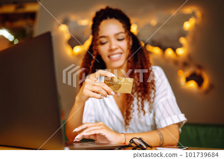 Young woman sitting at cafe making online shopping, using credit card and laptop. Online shopping 101739684