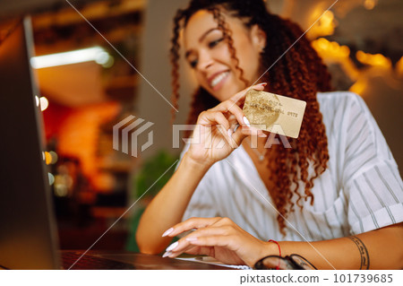 Young woman sitting at cafe making online shopping, using credit card and laptop. Online shopping 101739685