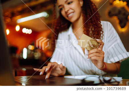 Young woman sitting at cafe making online shopping, using credit card and laptop. Online shopping 101739689