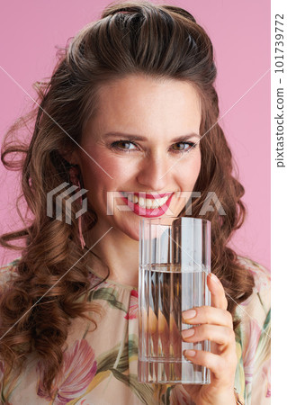 Portrait of smiling stylish woman in floral dress on pink 101739772