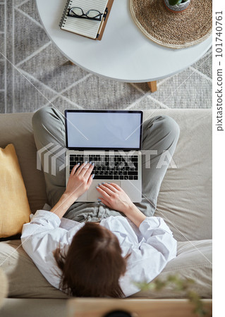 Mockup white screen laptop woman using computer sitting on sofa at home, top view 101740761