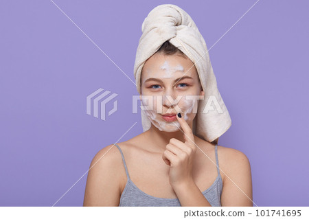 Image of lovely woman with thoughtful expression, keeps finger near corner of lips, looks at camera, applies facial mask for refreshing, wrapped in soft towel. Image of lovely woman with thoughtful expression, keeps finger near corner of lips, looks at camera, applies facial mask for refreshing, wrapped in soft towel. 101741695
