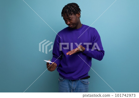 modern black american young guy with dreadlocks uses phone for online payments 101742973