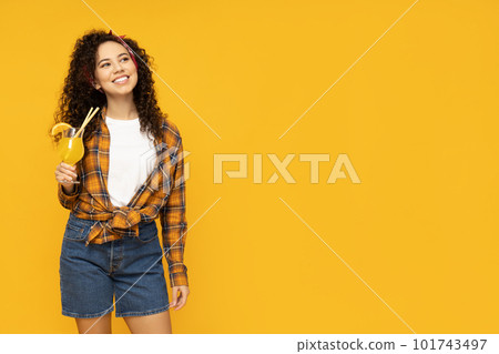 Young woman with cocktail on yellow background Young woman with cocktail on yellow background 101743497