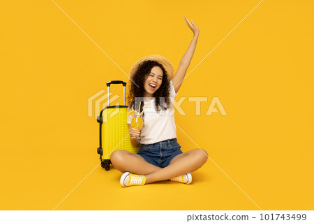 Young woman with suitcase on yellow background Young woman with suitcase on yellow background 101743499