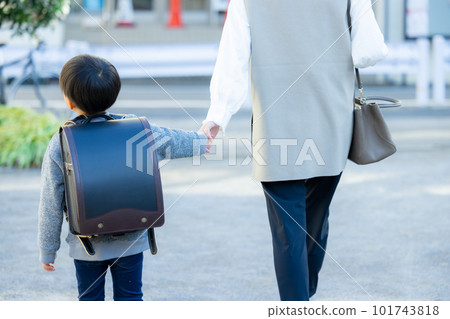 An elementary school boy walking hand in hand with his mother An elementary school boy walking hand in hand with his mother 101743818