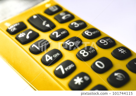Closeup on keypad of a yellow hand-held phone 101744115