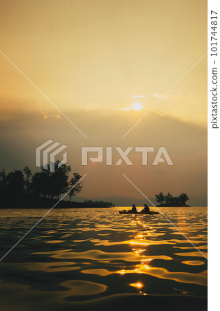Silhouettes of people in kayak at sunset. 101744817
