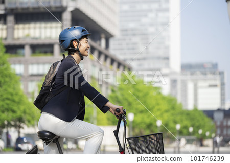 Middle-aged businesswoman commuting by bicycle Middle-aged businesswoman commuting by bicycle 101746239