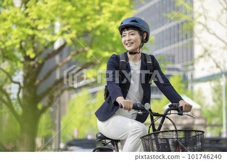 Middle-aged businesswoman commuting by bicycle Middle-aged businesswoman commuting by bicycle 101746240