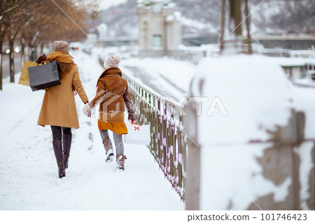 mom and child in coat, hat, scarf and mittens walking mom and child in coat, hat, scarf and mittens walking 101746423