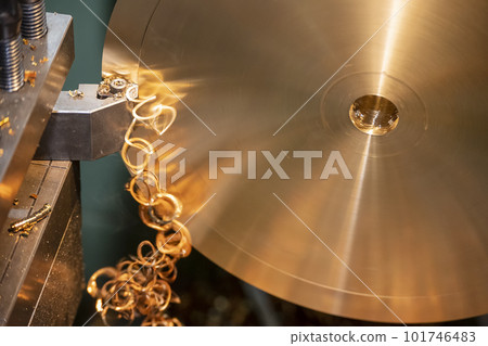 Close-up the lathe machine finish cutting the brass disk parts by lathe tools. Close-up the lathe machine finish cutting the brass disk parts by lathe tools. 101746483