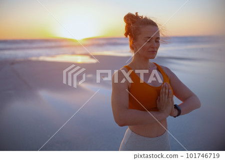 fitness sports woman at beach at sunset meditating 101746719