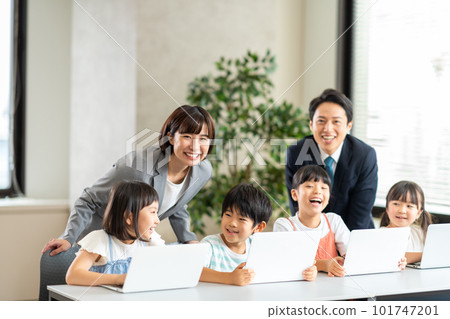 Elementary school students and teachers studying on a laptop. 101747201
