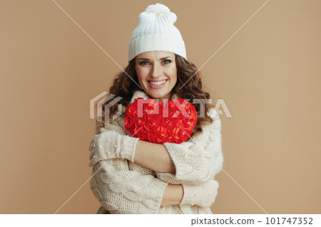 happy elegant woman in beige sweater, mittens and hat on beige happy elegant woman in beige sweater, mittens and hat on beige 101747352