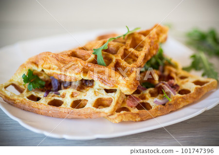 Egg omelette stuffed with onions and herbs, fried in the form of waffles 101747396