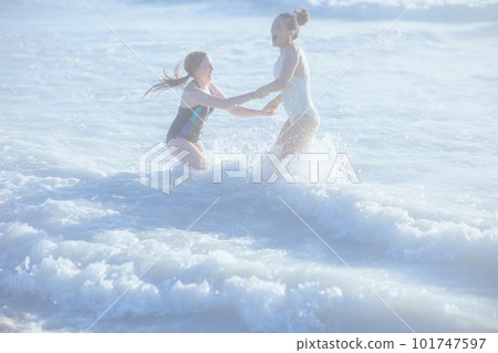 smiling stylish mother and child at beach having fun time 101747597