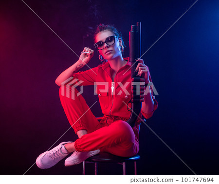 sexy bully girl smokes a cigarette with a shotgun on a dark background in neon light and a haze of copy paste sexy bully girl smokes a cigarette with a shotgun on a dark background in neon light and a haze of copy paste 101747694