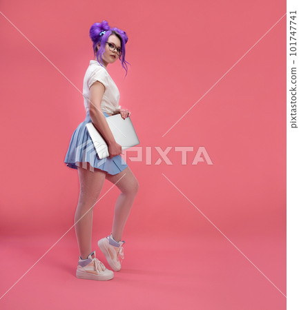 sexy girl with glasses with purple hair with a laptop in summer clothes on a pink background copy paste 101747741