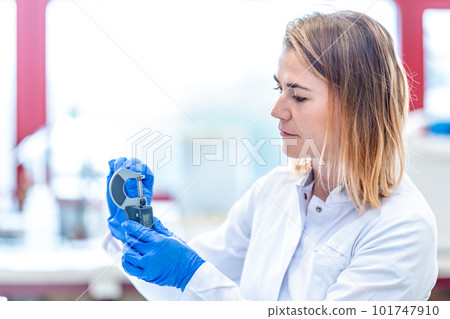 accurate mechanical measurement of the sample in a research laboratory. young caucasian woman scientist conducts research 101747910