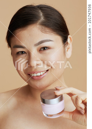 Portrait of young asian female with facial cream jar 101747936