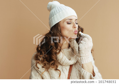 elegant woman in beige sweater, mittens and hat 101748031