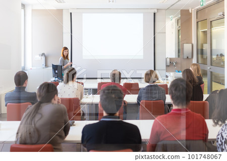Female speaker giving presentation in lecture hall at university workshop. Audience in conference hall. Rear view of unrecognized participant in audience. Scientific conference event. Female speaker giving presentation in lecture hall at university workshop. Audience in conference hall. Rear view of unrecognized participant in audience. Scientific conference event. 101748067