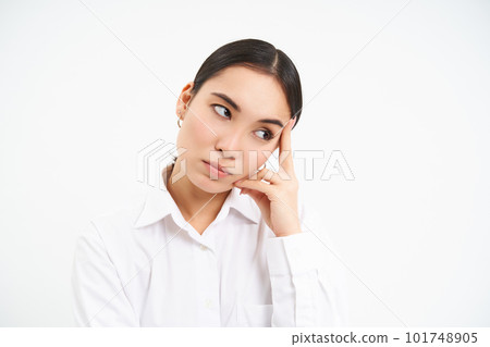 Portrait of annoyed, bored korean woman roll eyes, looks aside with bothered, tired face expression, stands over white background Portrait of annoyed, bored korean woman roll eyes, looks aside with bothered, tired face expression, stands over white background 101748905