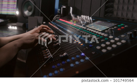 Audio engineer uses mixing console in recording studio 101749564