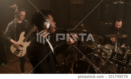 Vocalist keeps hands on microphone stand and sings Vocalist keeps hands on microphone stand and sings 101749576