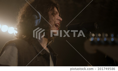 Vocalist sings into microphone in soundproof room Vocalist sings into microphone in soundproof room 101749586
