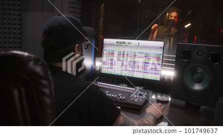 Audio engineer works with male singer in recording studio Audio engineer works with male singer in recording studio 101749637