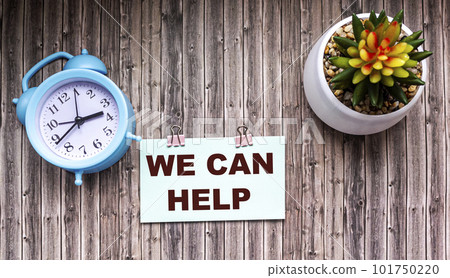 We can help text on a sticker, a flower in a pot and an alarm clock on a wooden table. 101750220