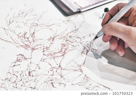 Close-up shot of the hand of a comic book artist painting a manga cartoon character in ink line drawing Close-up shot of the hand of a comic book artist painting a manga cartoon character in ink line drawing 101750323