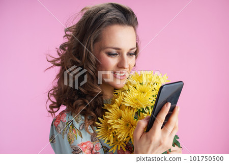 happy stylish woman using smartphone app on pink 101750500