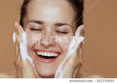 happy young woman with foaming facial cleanser washing face happy young woman with foaming facial cleanser washing face 101750695
