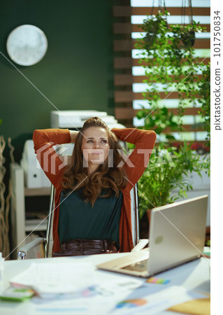 relaxed trendy business owner woman in green office 101750834