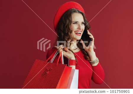smiling stylish woman in dress and beret talking on phone 101750901