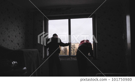 Silhouettes of workers installing new plastic windows. 101750980