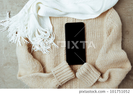 winter flat lay with scarf, smartphone and sweater 101751052