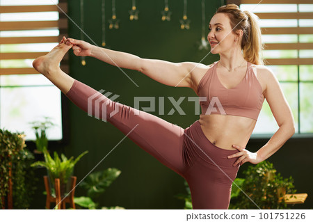 30 years old housewife in green living room doing yoga 101751226