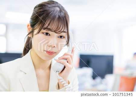 Woman receiving a phone call in the office Woman receiving a phone call in the office 101751345