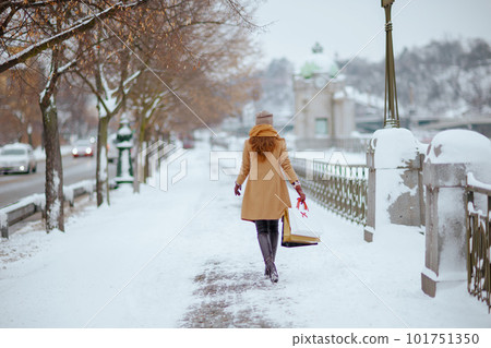 Seen from behind woman in brown hat and scarf 101751350