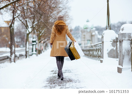 Seen from behind woman in brown hat and scarf 101751353