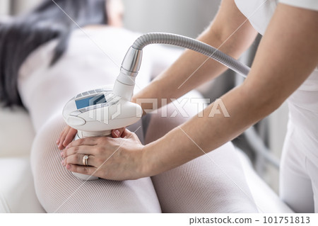 Woman performs LPG enermology skincare treatment of a female's back thighs 101751813