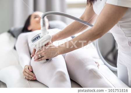 Female gets cellulite thighs treatment by an LPG endermology medical device 101751816