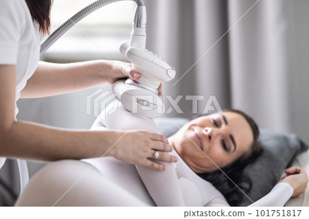 Arm skincare and beautification treatment of a woman in cosmetics studio by an LPG endermology 101751817