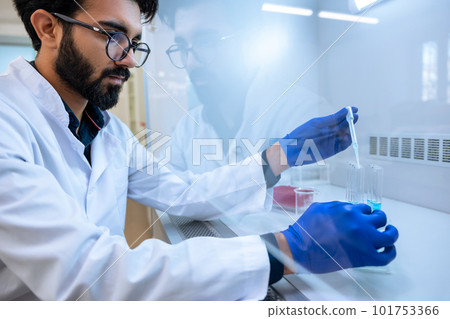 Scientist man testing chemical sample in flask at laboratory with lab glassware. 101753366