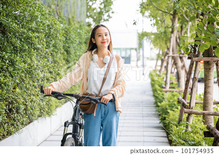Asian young woman walking alongside with bicycle on summer in park countryside outdoor, Happy female smiling walk down the street with her bike on city road, ECO environment, healthy holiday travel Asian young woman walking alongside with bicycle on summer in park countryside outdoor, Happy female smiling walk down the street with her bike on city road, ECO environment, healthy holiday travel 101754935